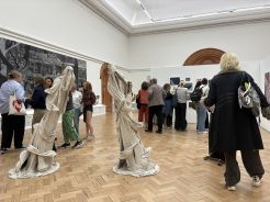 Visitors view artworks and fabric sculptures at the More to Come show.